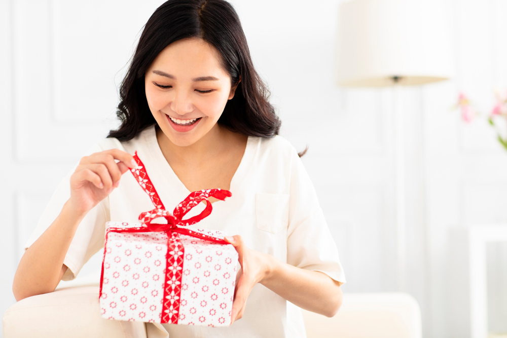 Happy,young,woman,unpacking,gift,box